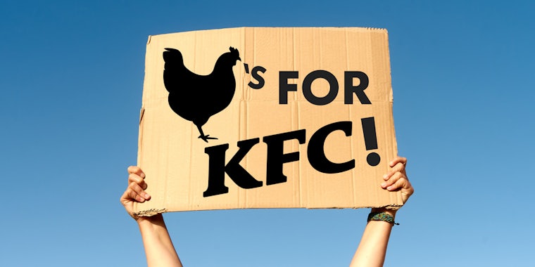 Chicken's for KFC sign in hand