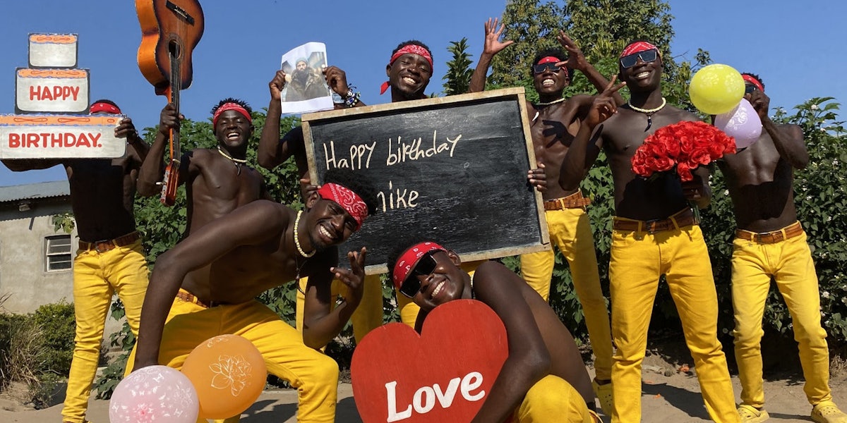 Group of men dancing and holding photos
